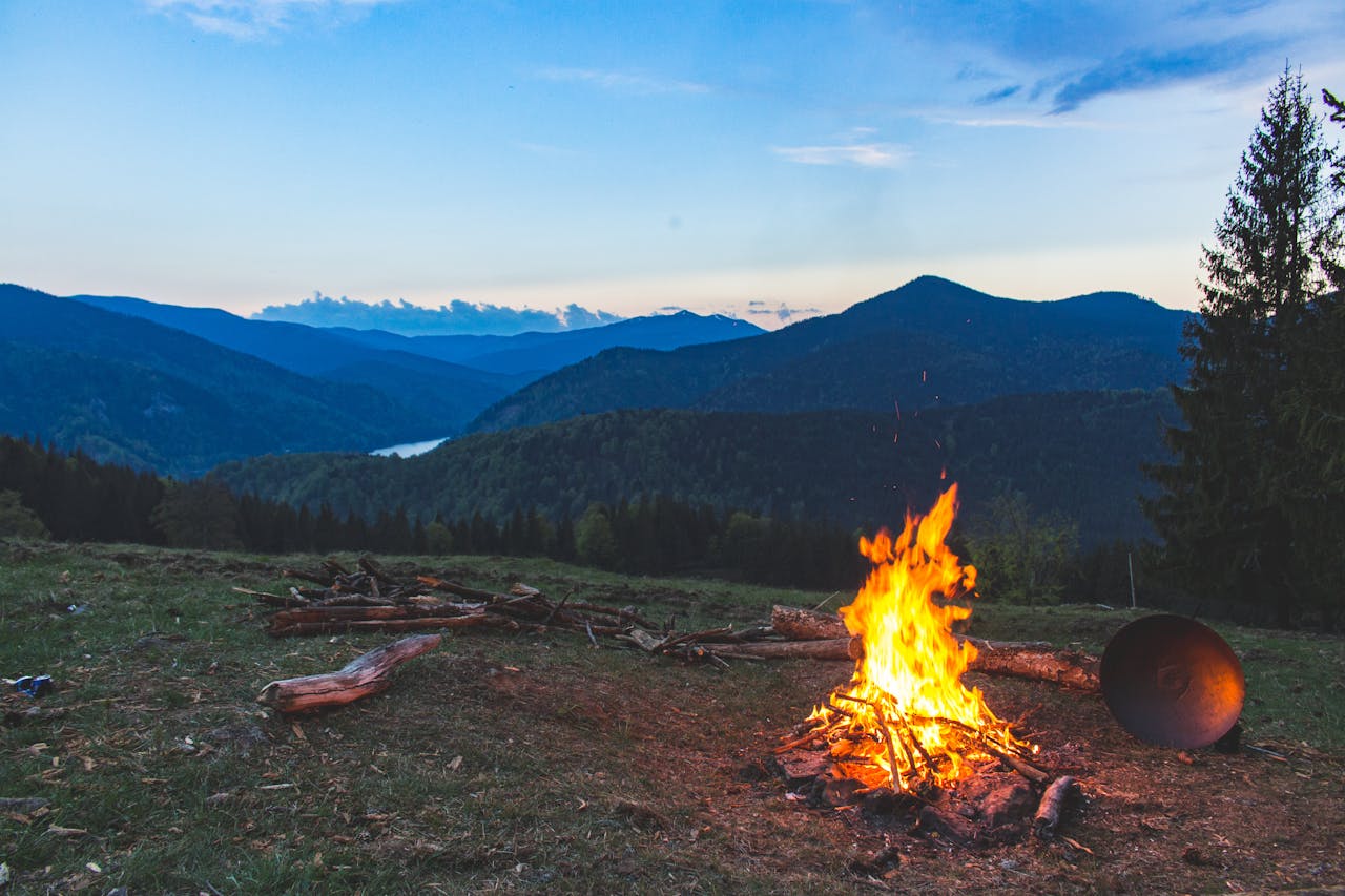 services-01 Cozy campfire against a mountain backdrop at twilight in Valea Drăganului, Romania.